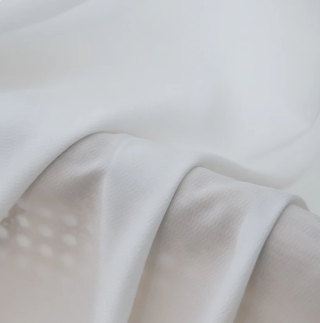 Close-up of sheer white privacy curtain fabric with soft, light-filtering texture