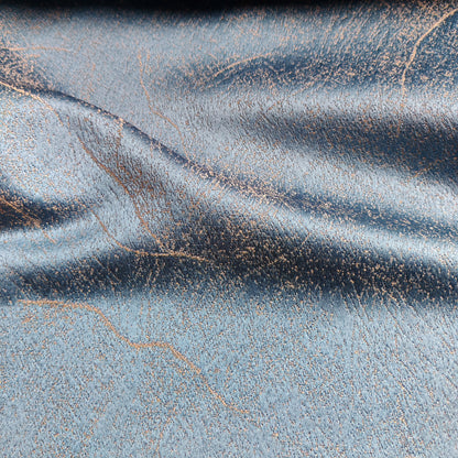 Blue metallic curtain fabric with gold speckled pattern and soft textured folds