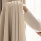 Hand holding beige textured blackout curtain in soft natural light