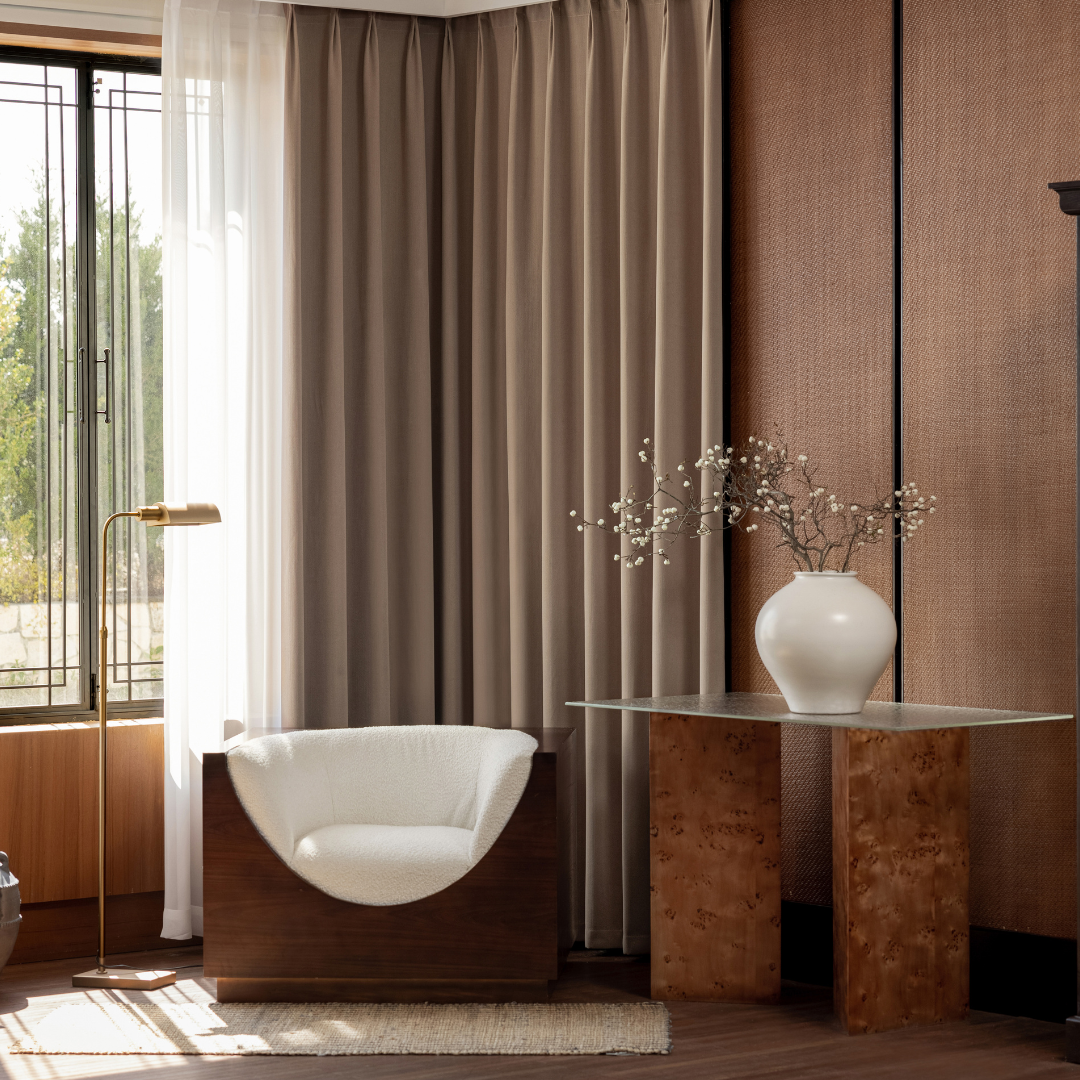 Deep walnut blackout curtains in a modern living room with accent chair and glass table