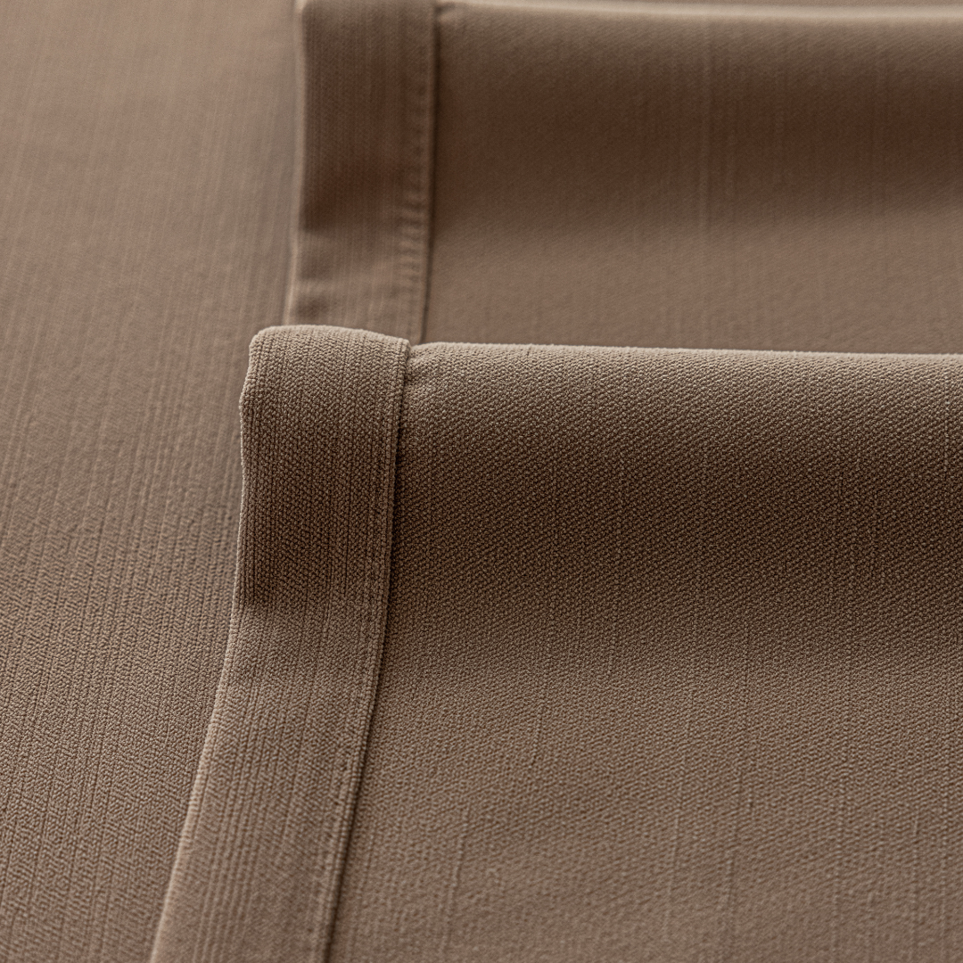 Close-up of deep walnut brown curtain fabric with textured weave and stitched edges