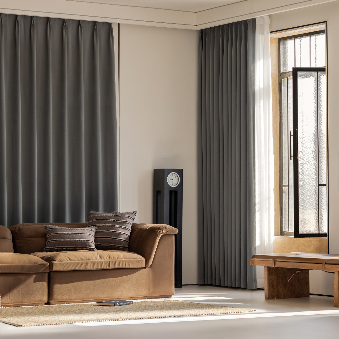 Living room with graphite ash blackout curtains, brown sofa, and natural light