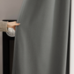 Hand holding graphite ash blackout curtain in modern interior setting
