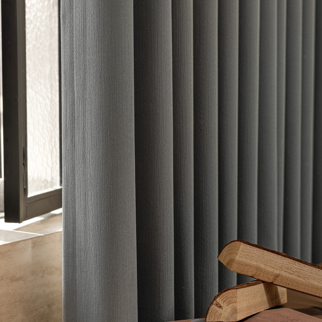 Modern graphite ash blackout curtains by a window with textured glass