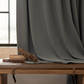 Graphite ash blackout curtain draped beside window, books, log on wooden bench