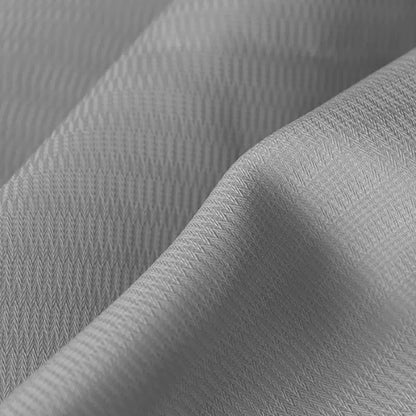 Close-up of light grey curtain fabric with a subtle herringbone texture