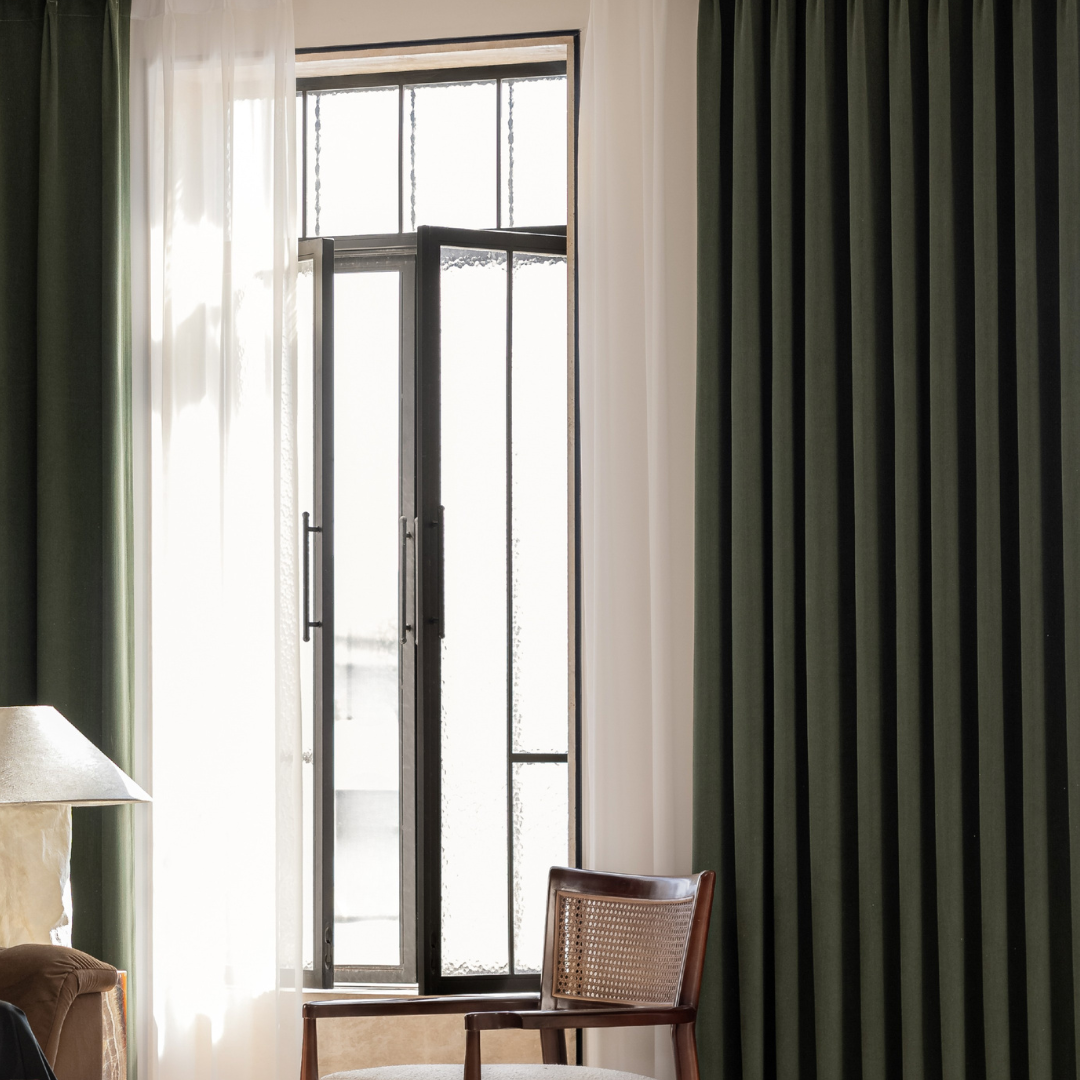 Modern living room with olive green blackout curtains and sheer white drapes on window