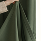 Hand holding olive green blackout curtain fabric close-up