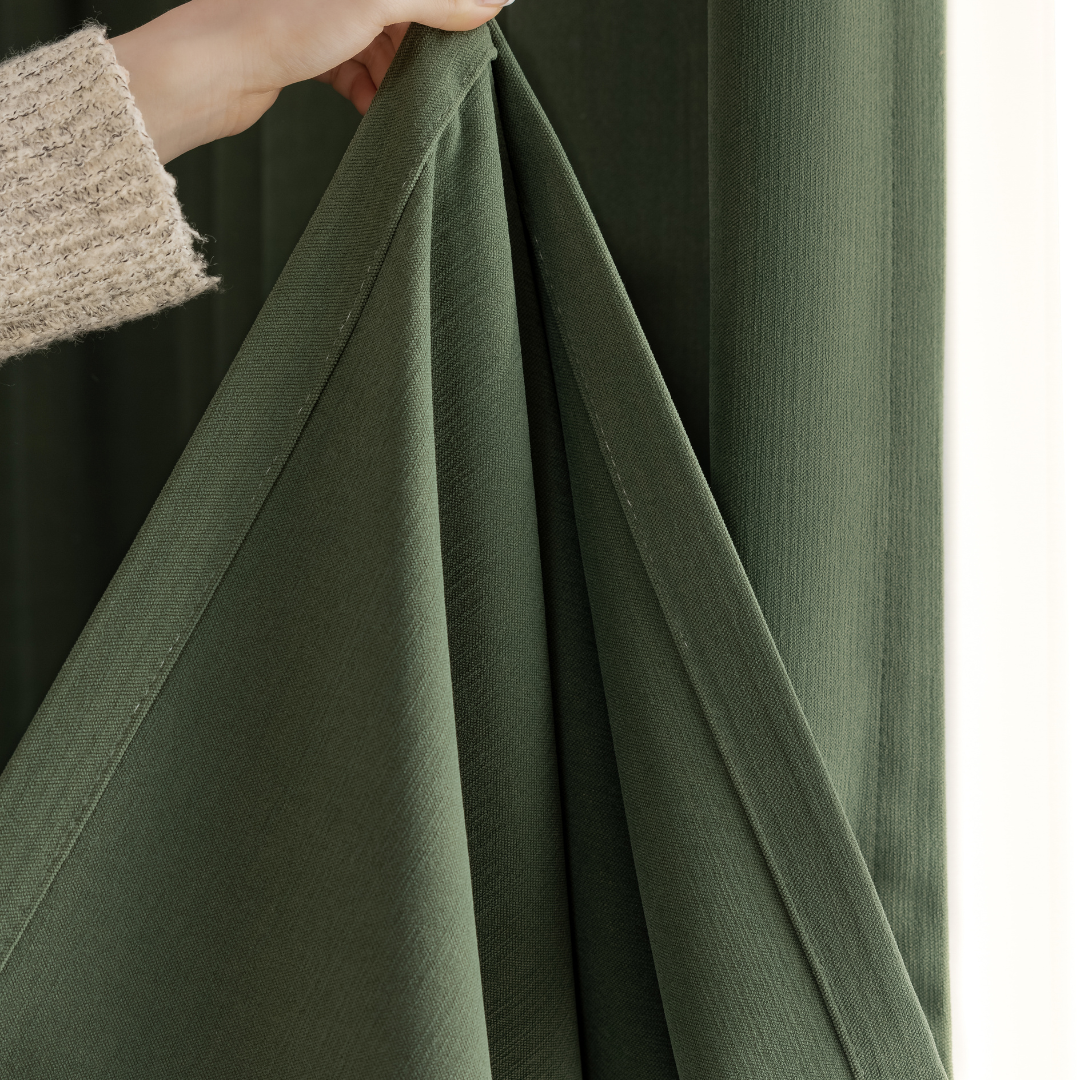 Hand holding olive green blackout curtain fabric close-up