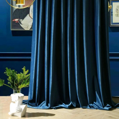Blue velvet blackout curtains in a modern living room with wall art and decorative plants